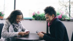 couple holding hands cafe smartphone