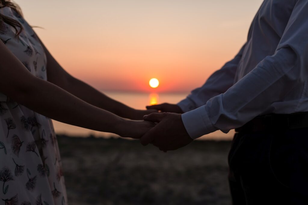 mature couple holding hands sunset