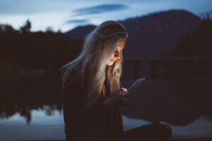 woman comparing dating apps smartphone night