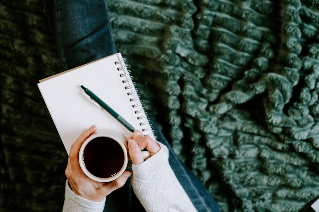 person writing notebook journal reflection