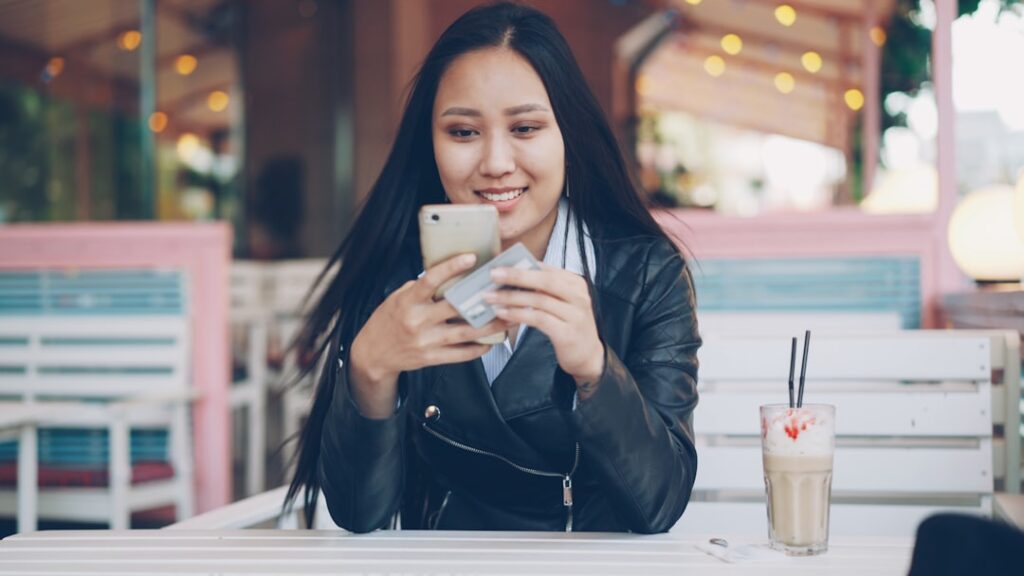 japanese woman reading reviews on smartphone cafe