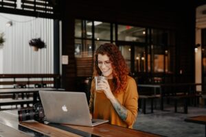young woman thinking laptop coffee