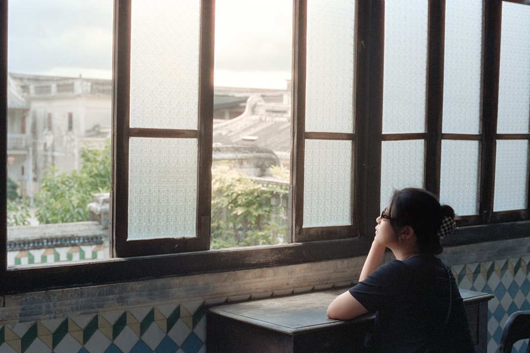 young woman thinking alone cafe window