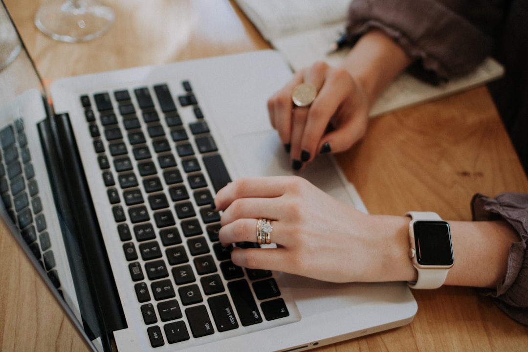 woman writing profile laptop home