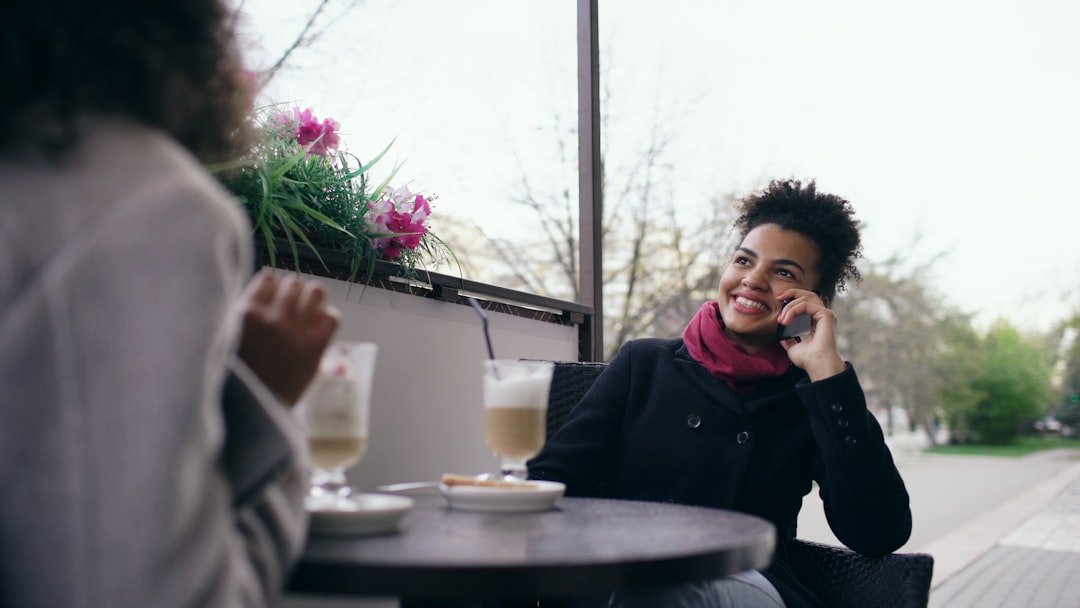 smiling man checking phone cafe