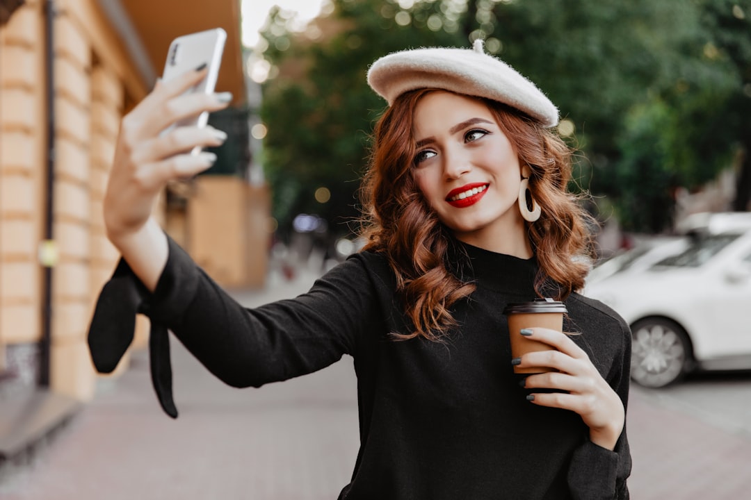 woman taking selfie scarf hat privacy