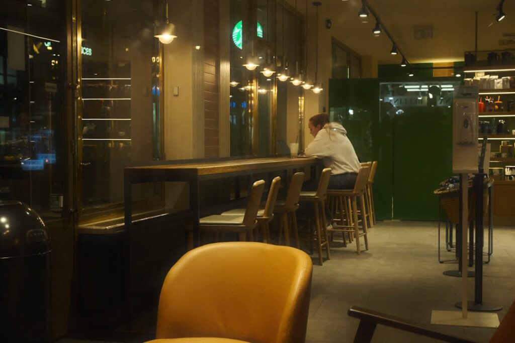 young man texting smartphone night cafe