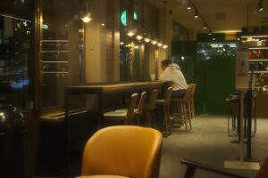 young man texting smartphone night cafe