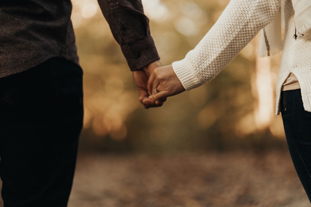 couple holding hands park autumn