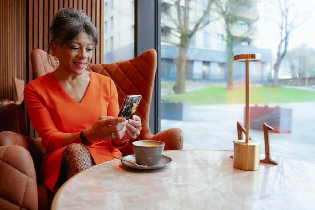 middle aged woman smartphone smiling cafe