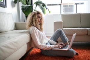 young woman researching online laptop home