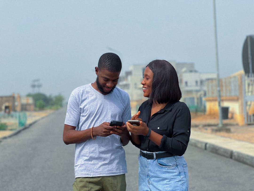 man woman comparing phone screens