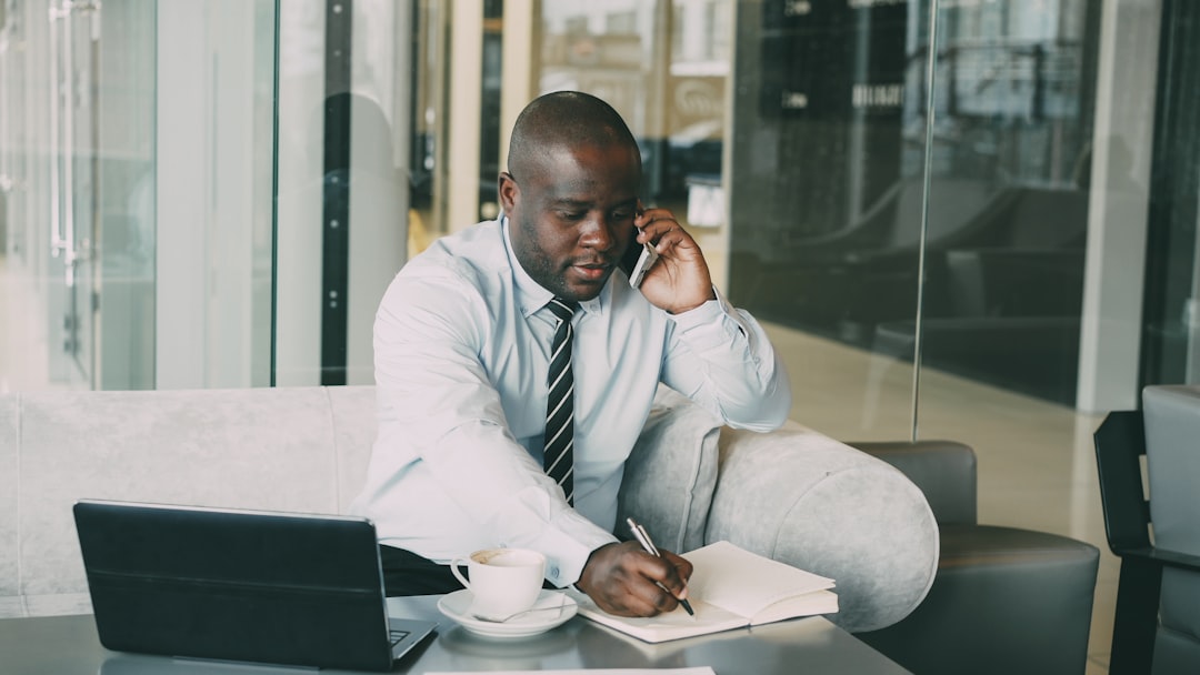 man writing notebook coffee desk