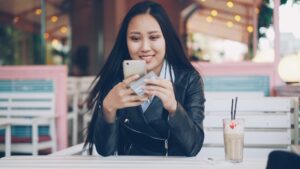 japanese woman reading reviews smartphone cafe