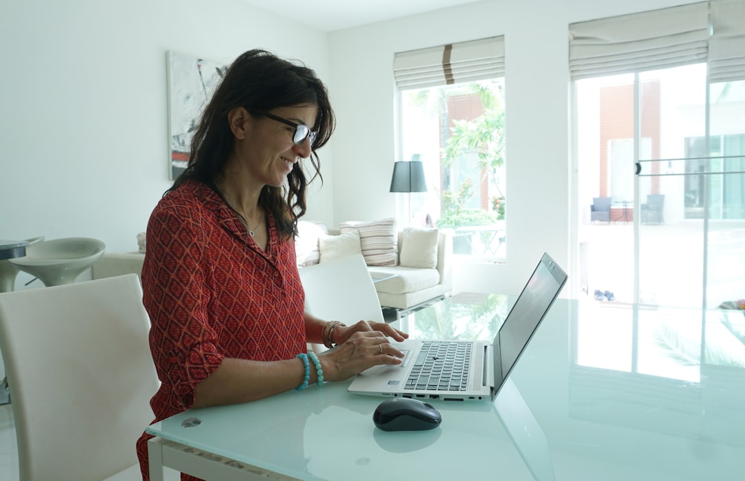 woman writing profile on laptop at home