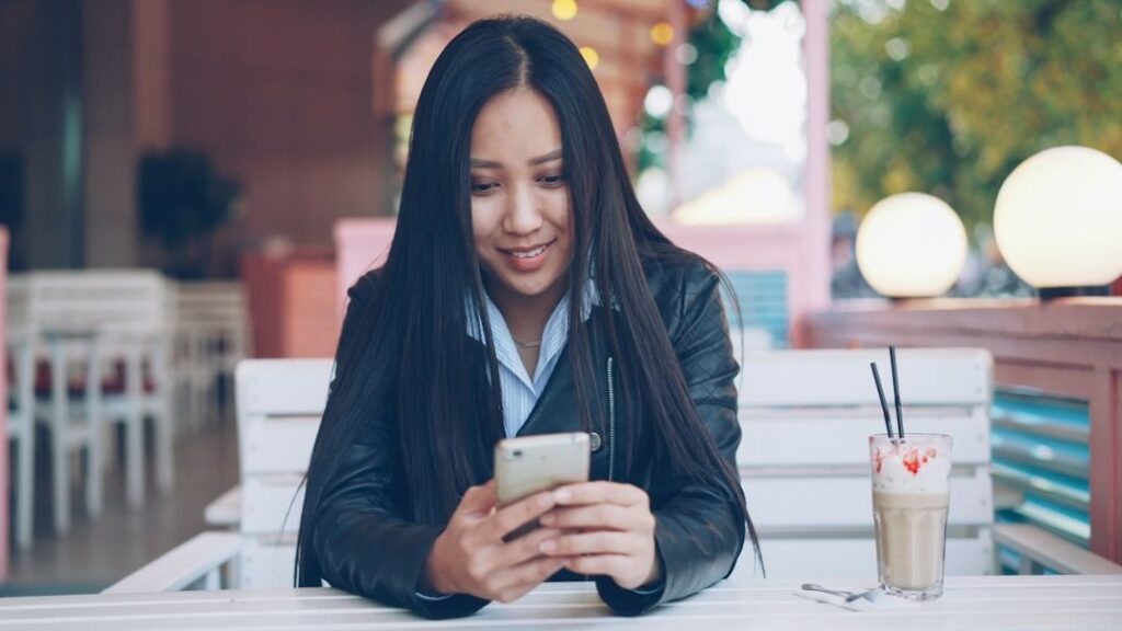 young woman using smartphone cafe