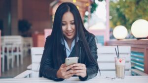 young woman using smartphone cafe