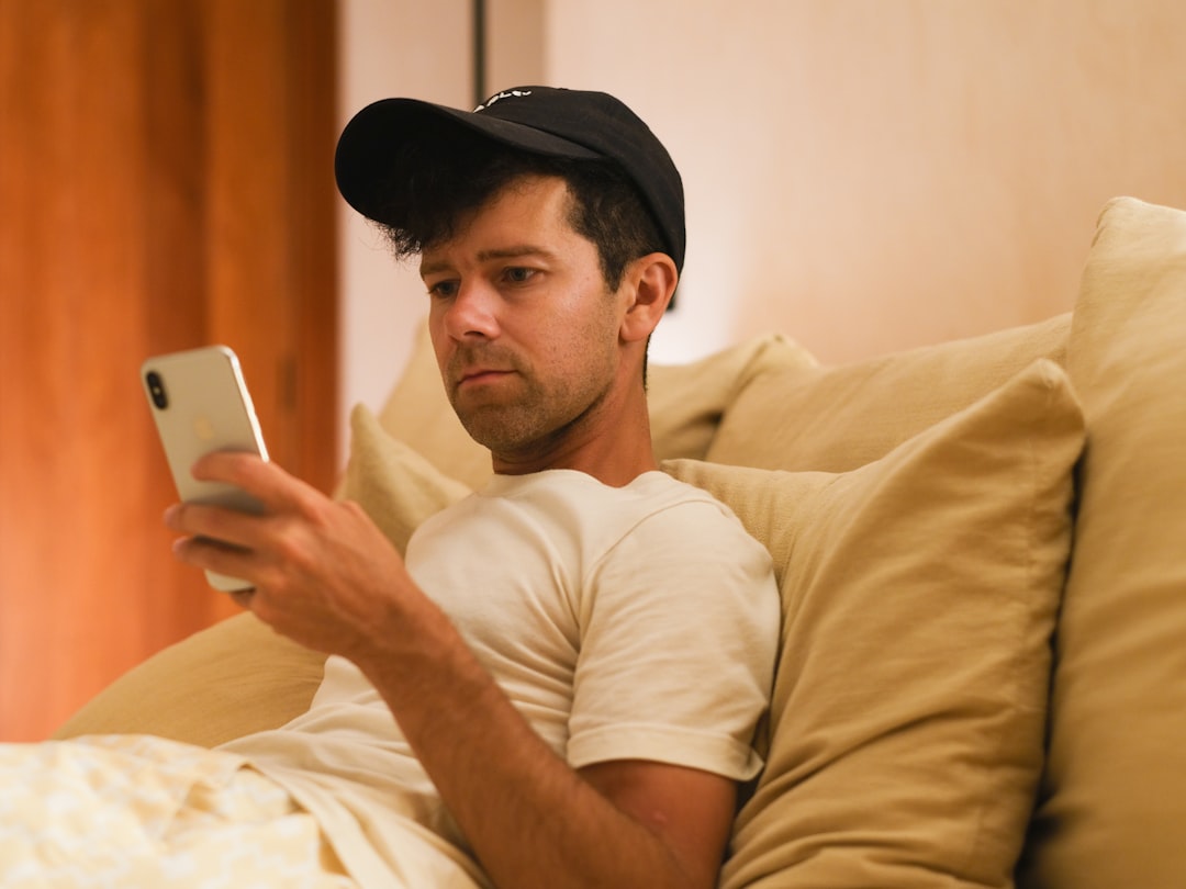 man swiping dating app smartphone bed night