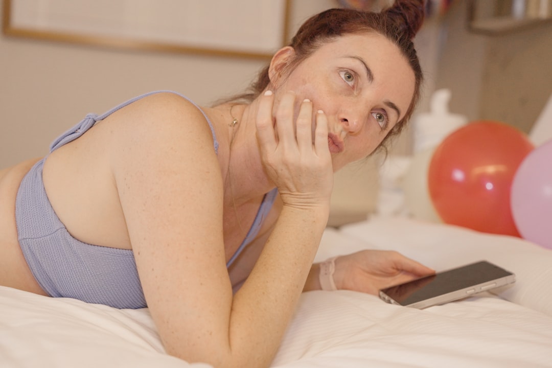 young woman worried smartphone bed