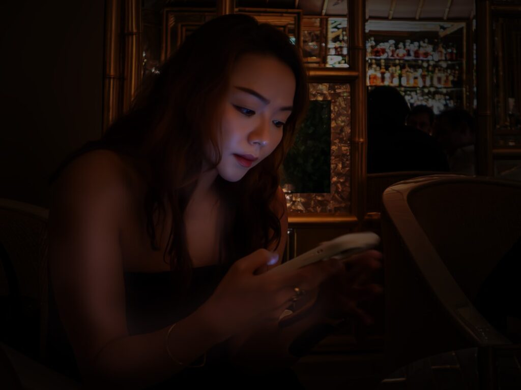 woman looking at smartphone at night worried