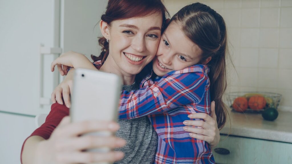 single mother smiling at smartphone at home