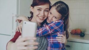 single mother smiling at smartphone at home