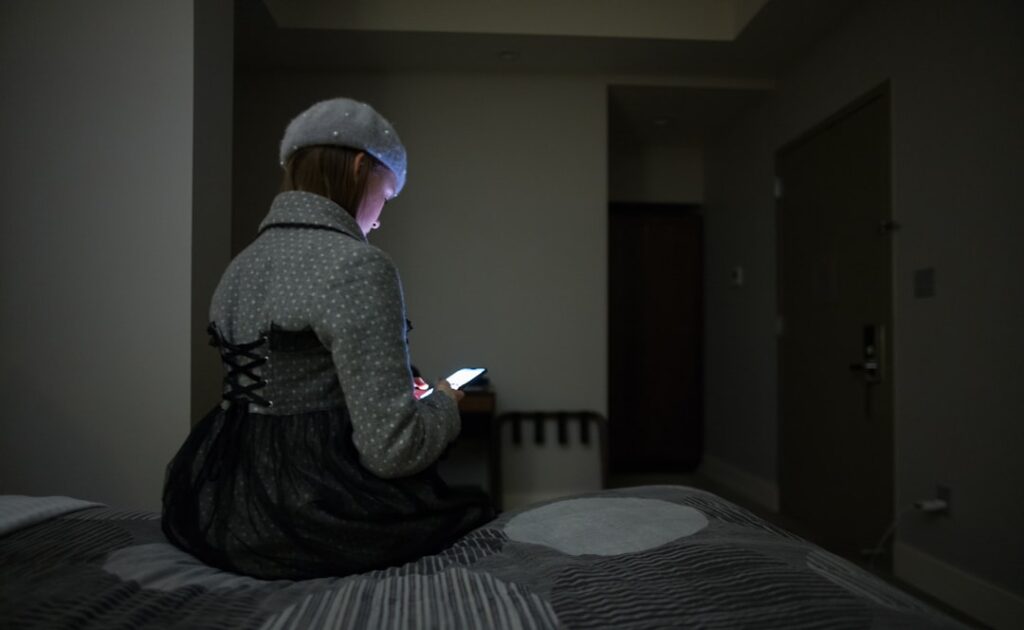 single mother using smartphone at night