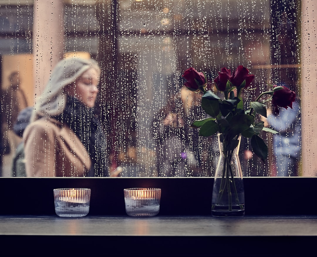 woman looking out rainy window alone