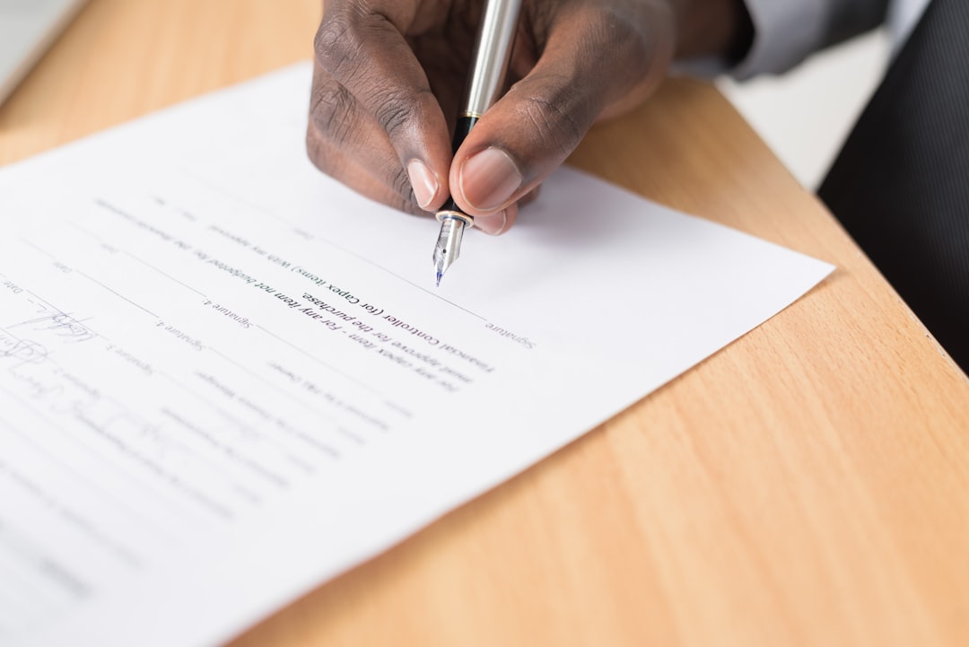 signing contract document with pen close up