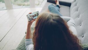 woman taking online love quiz on smartphone at home