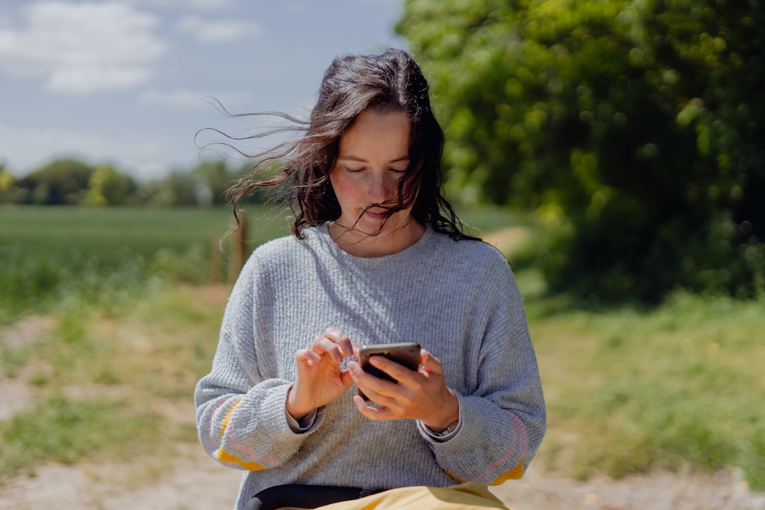 young woman using smartphone park