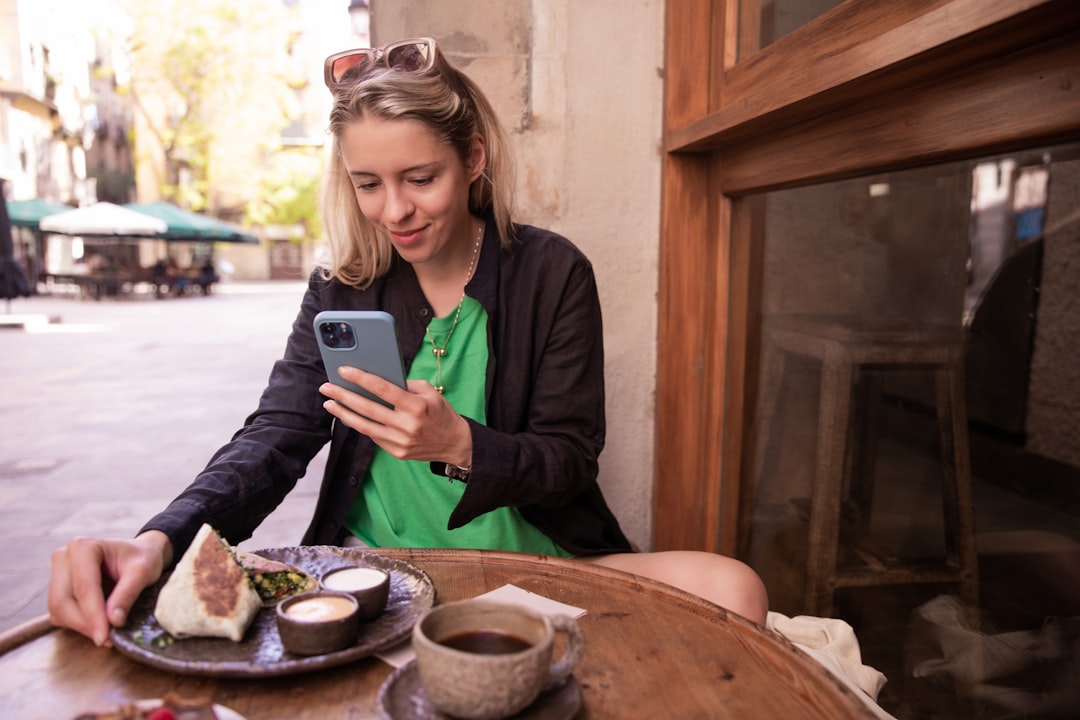 woman comparing dating apps on phone cafe