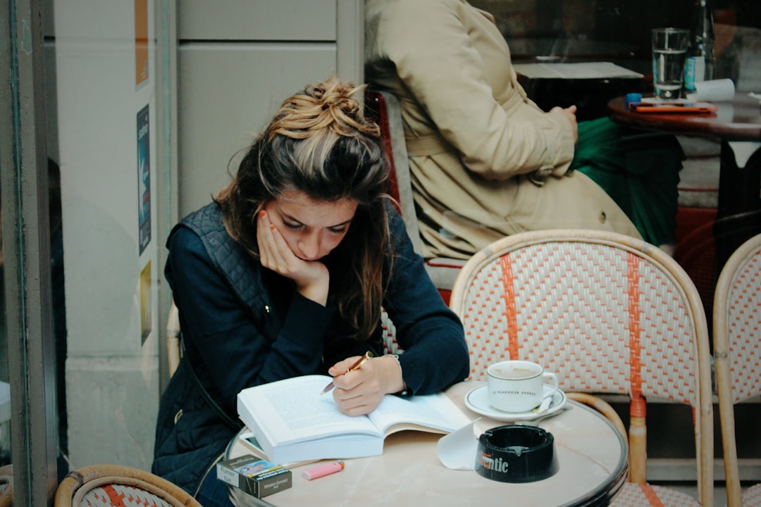 woman writing plan in notebook at cafe