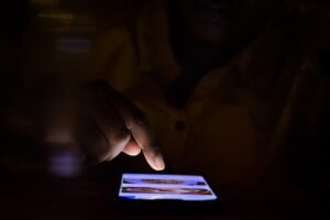man looking at smartphone dating app at night
