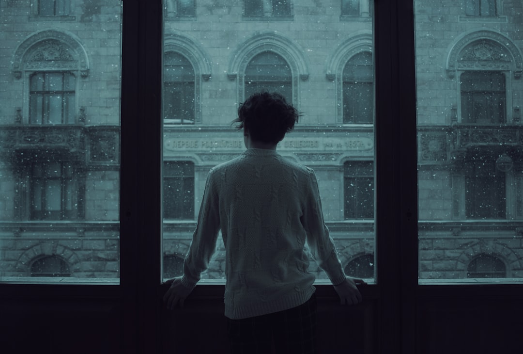 person disappointed thinking alone window
