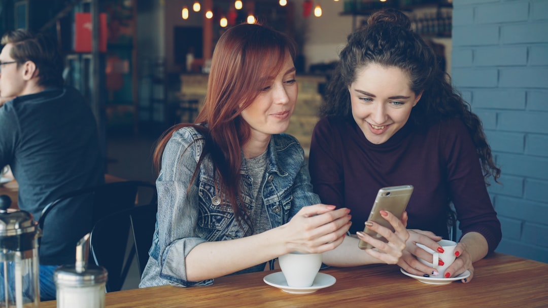 happy woman using smartphone cafe