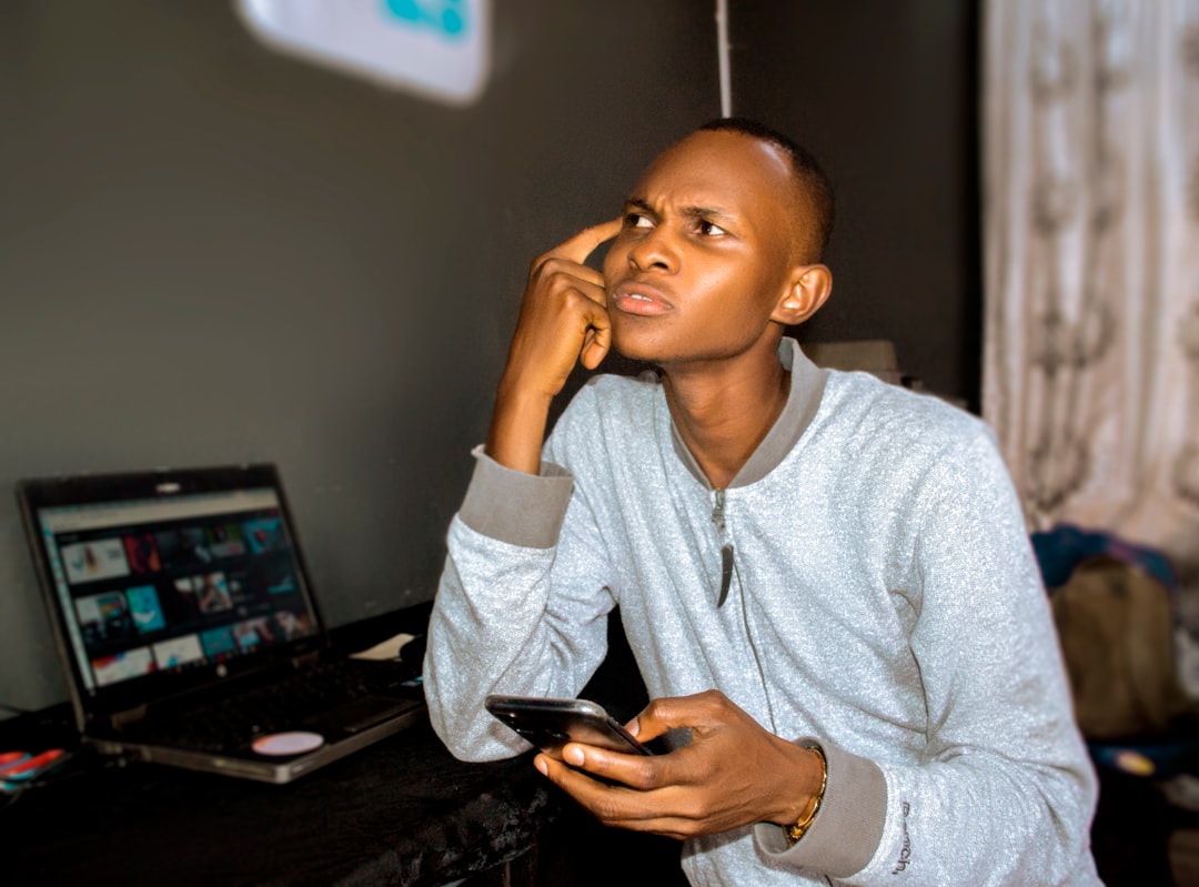 man looking at smartphone thinking
