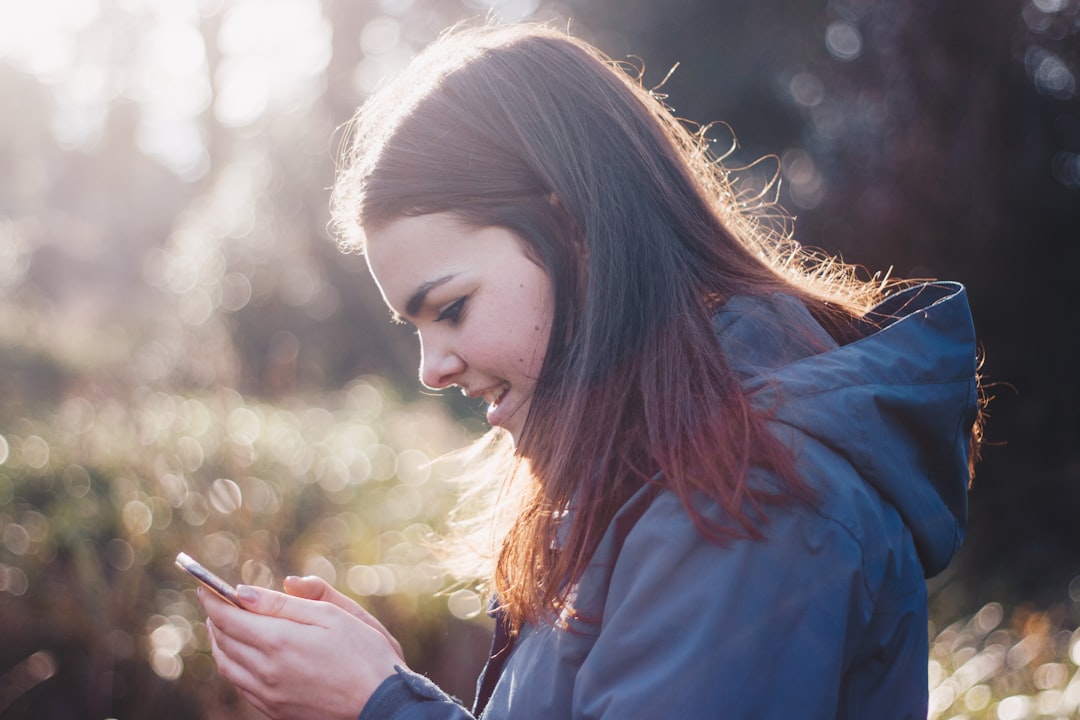 young woman using dating app outdoors