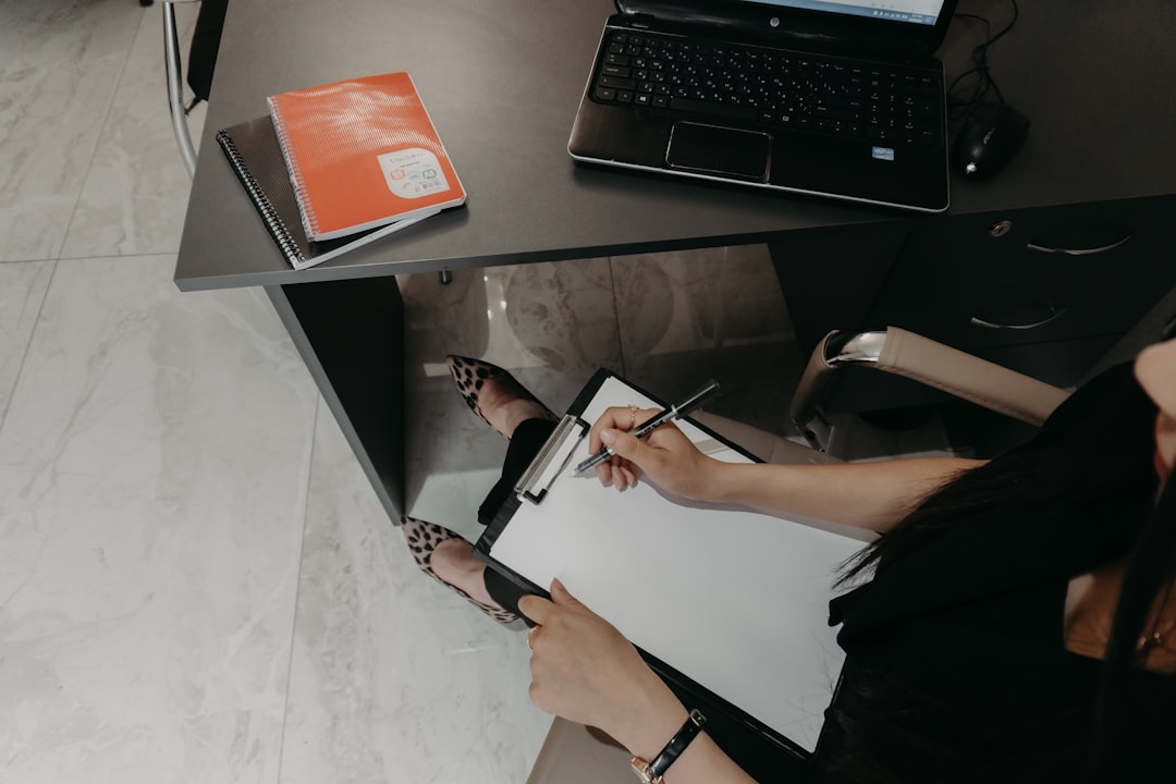 person taking notes on desk organized
