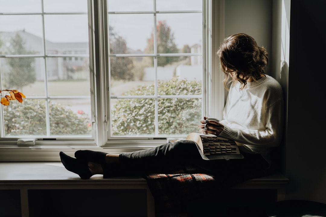 woman resting with coffee by window