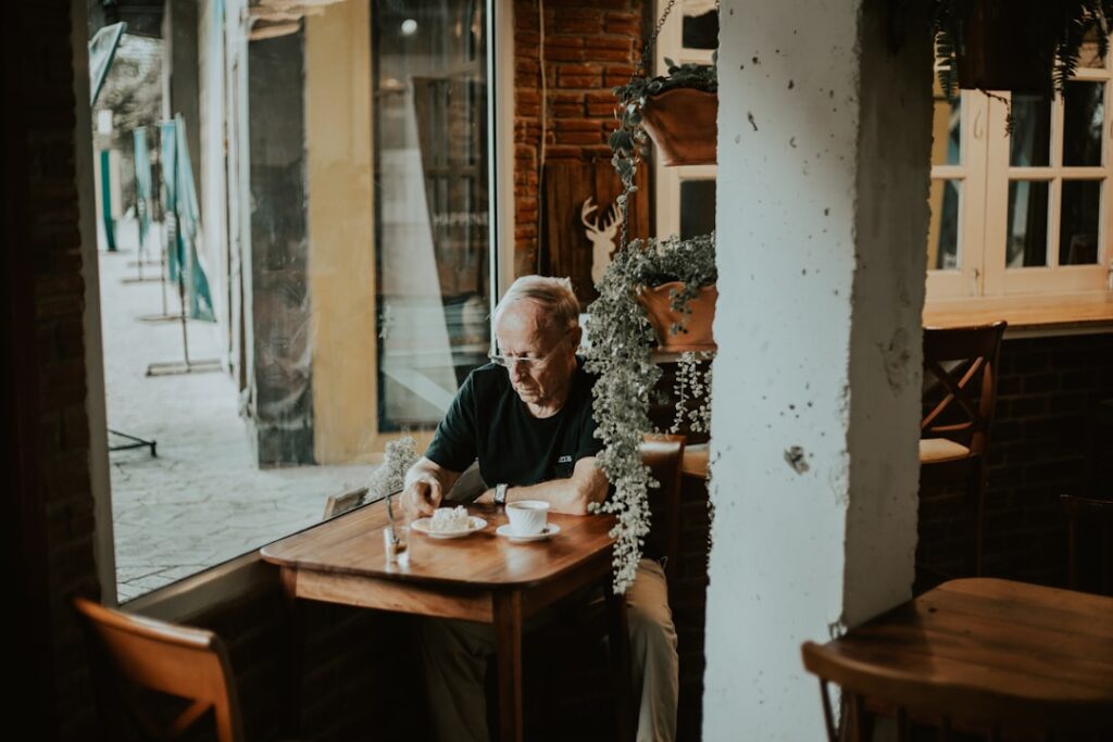 middle aged man using smartphone at cafe