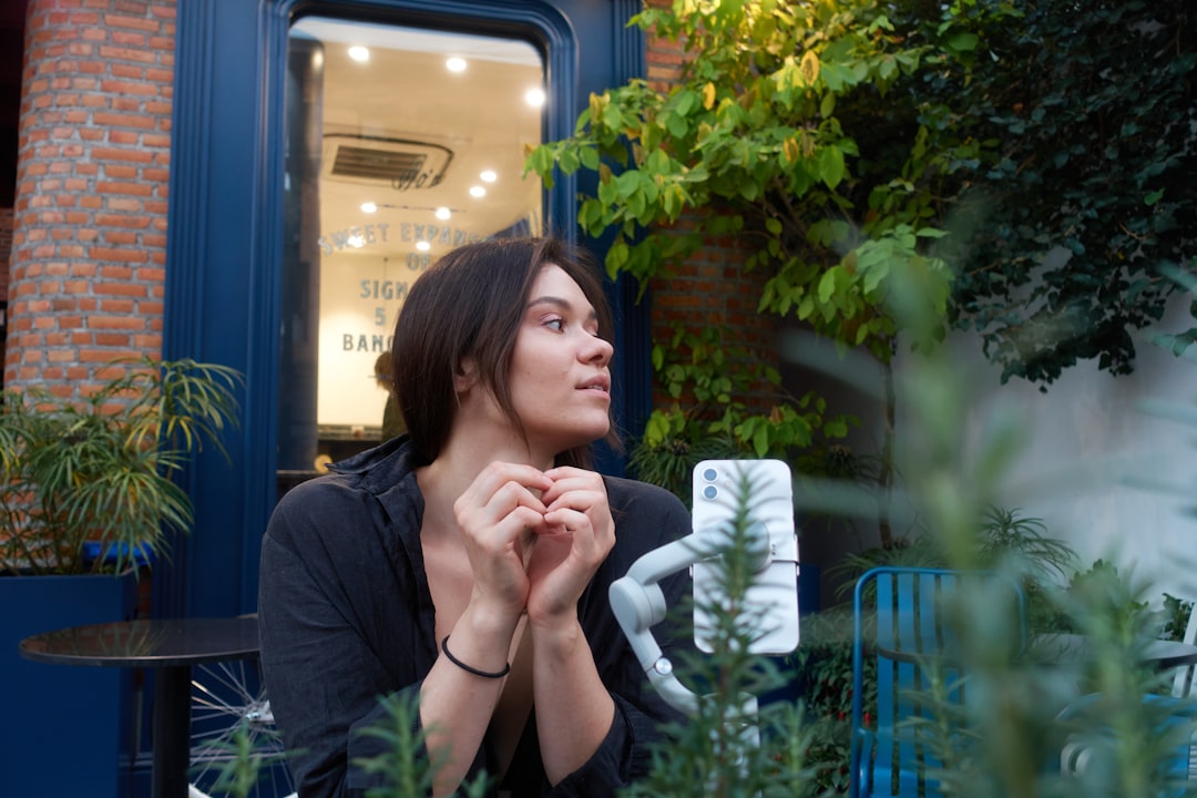 young woman thinking smartphone cafe