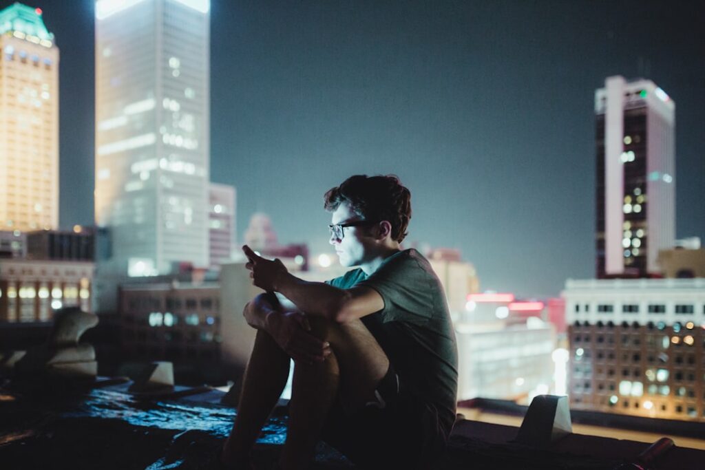 young man smartphone dating app night
