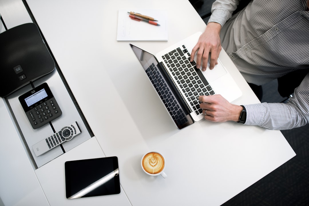 man typing on laptop coffee