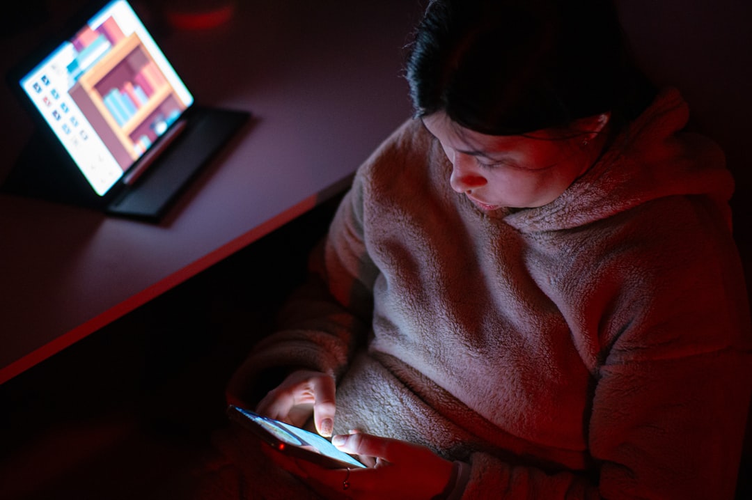 tired woman looking at smartphone at night