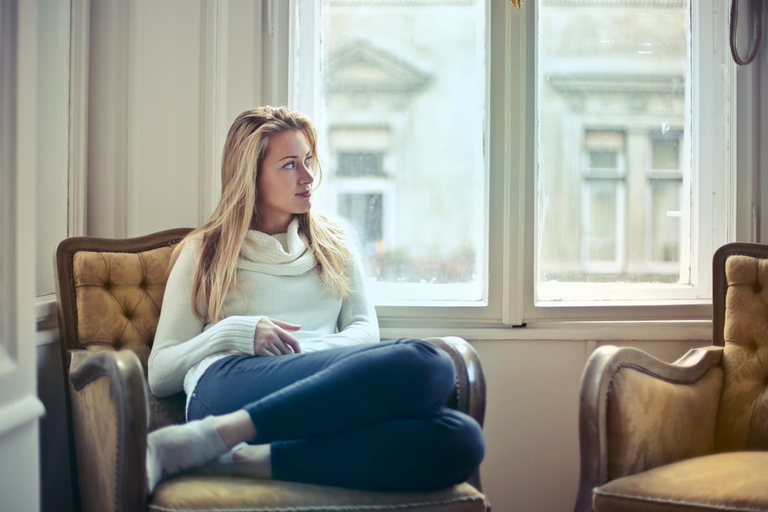 young woman thinking alone by window