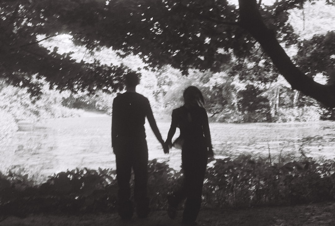 couple holding hands walking in park