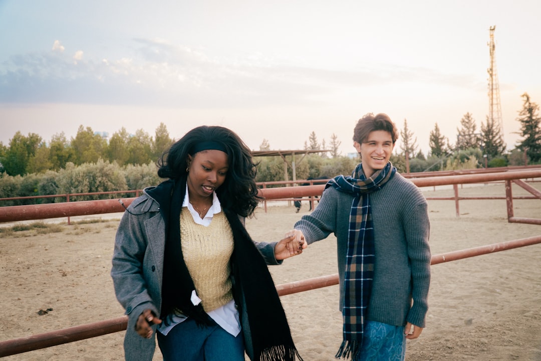 man and woman smiling walking together outdoors