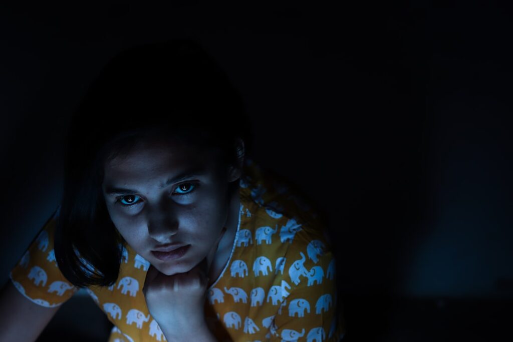 young woman worried smartphone night