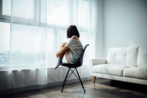 young woman thinking alone by window